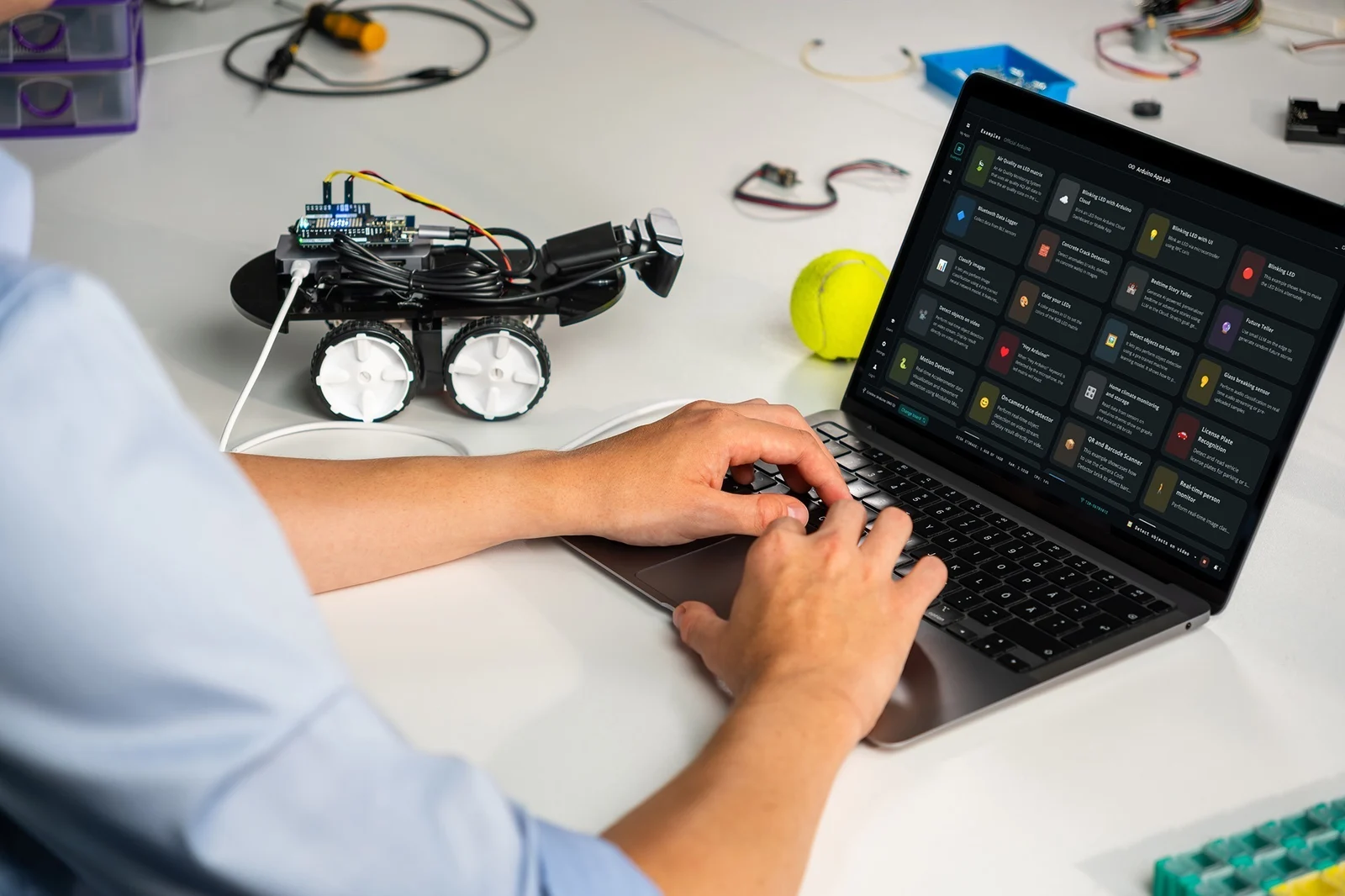 Arduino community members working with a laptop and a small robot