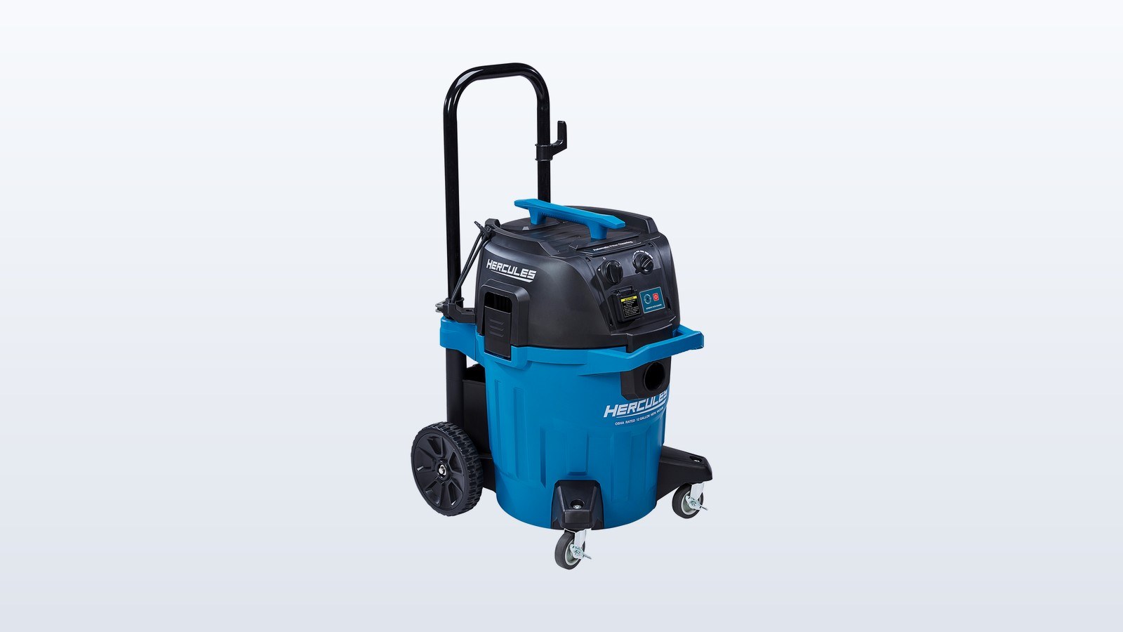 Blue and black HERCULES 12-gallon dust extractor on wheels with its hose attached, standing in a half-finished room