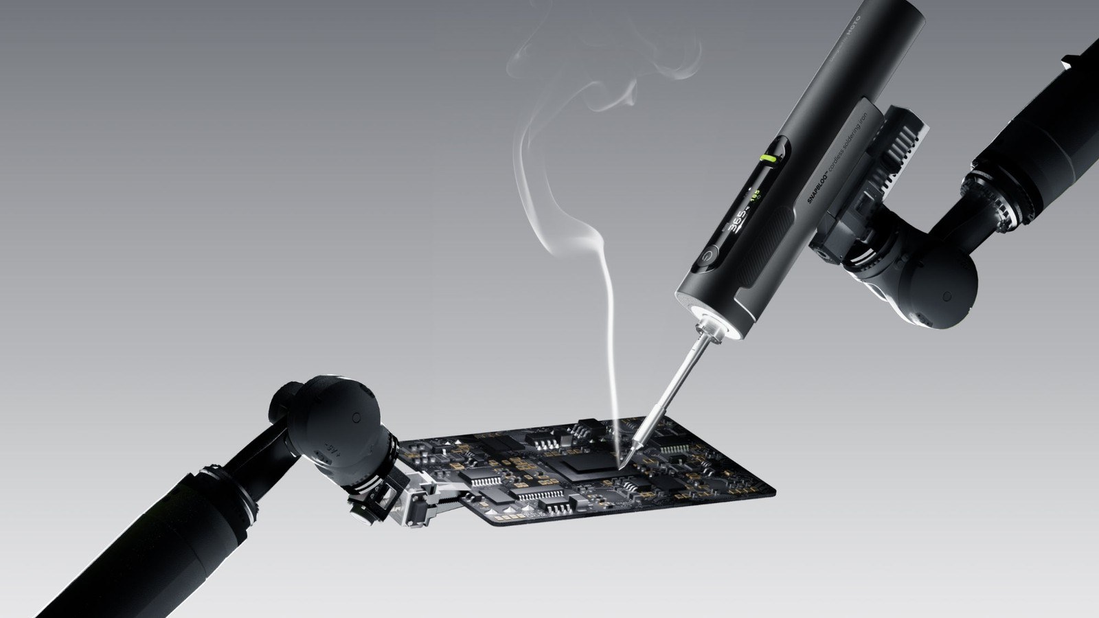 Hoto Snapbloq I-A06 cordless soldering iron working on a circuit board with a wisp of flux smoke