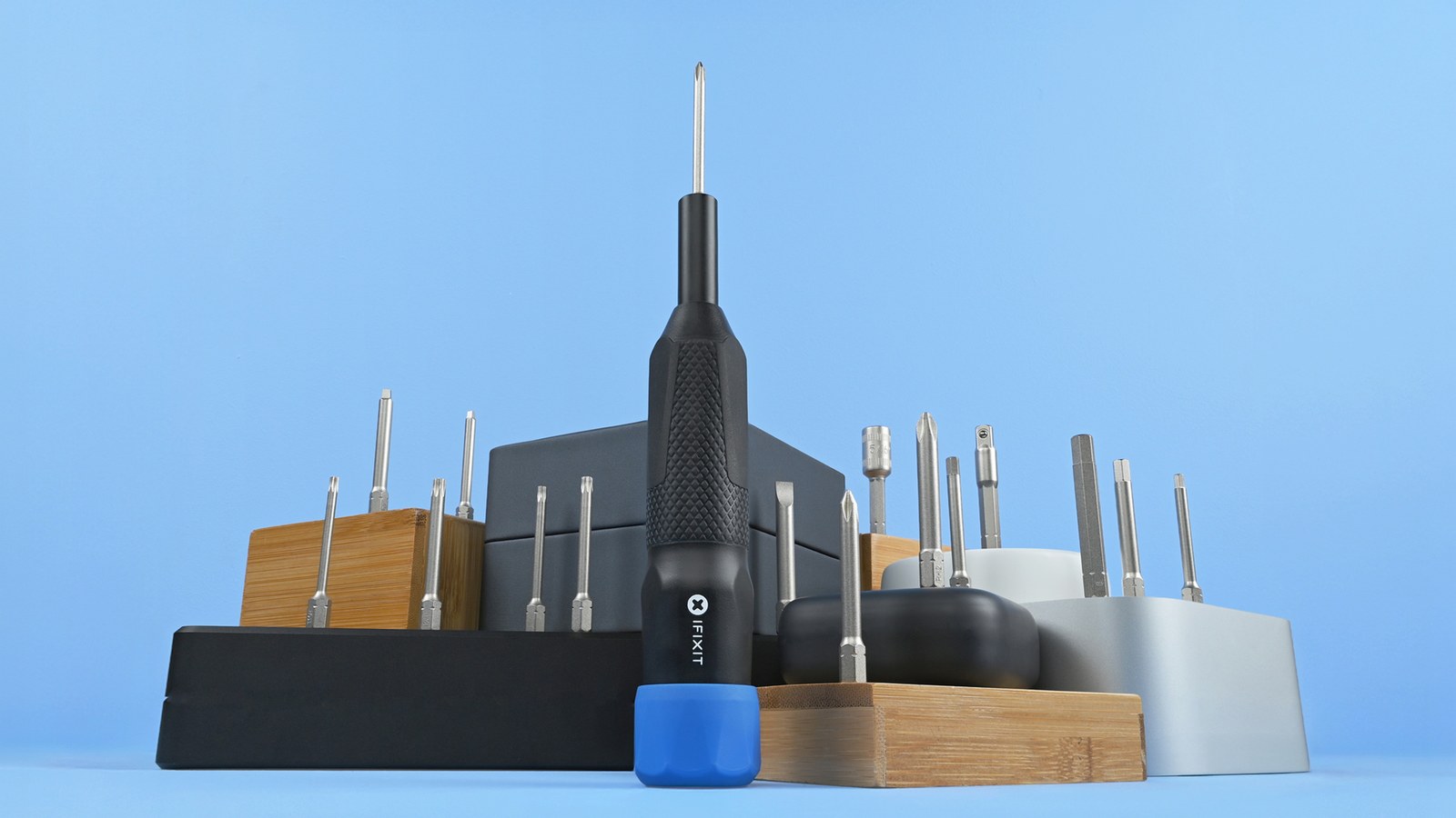 iFixit Megalodon driver with a blue cap standing among bit holders against a blue background