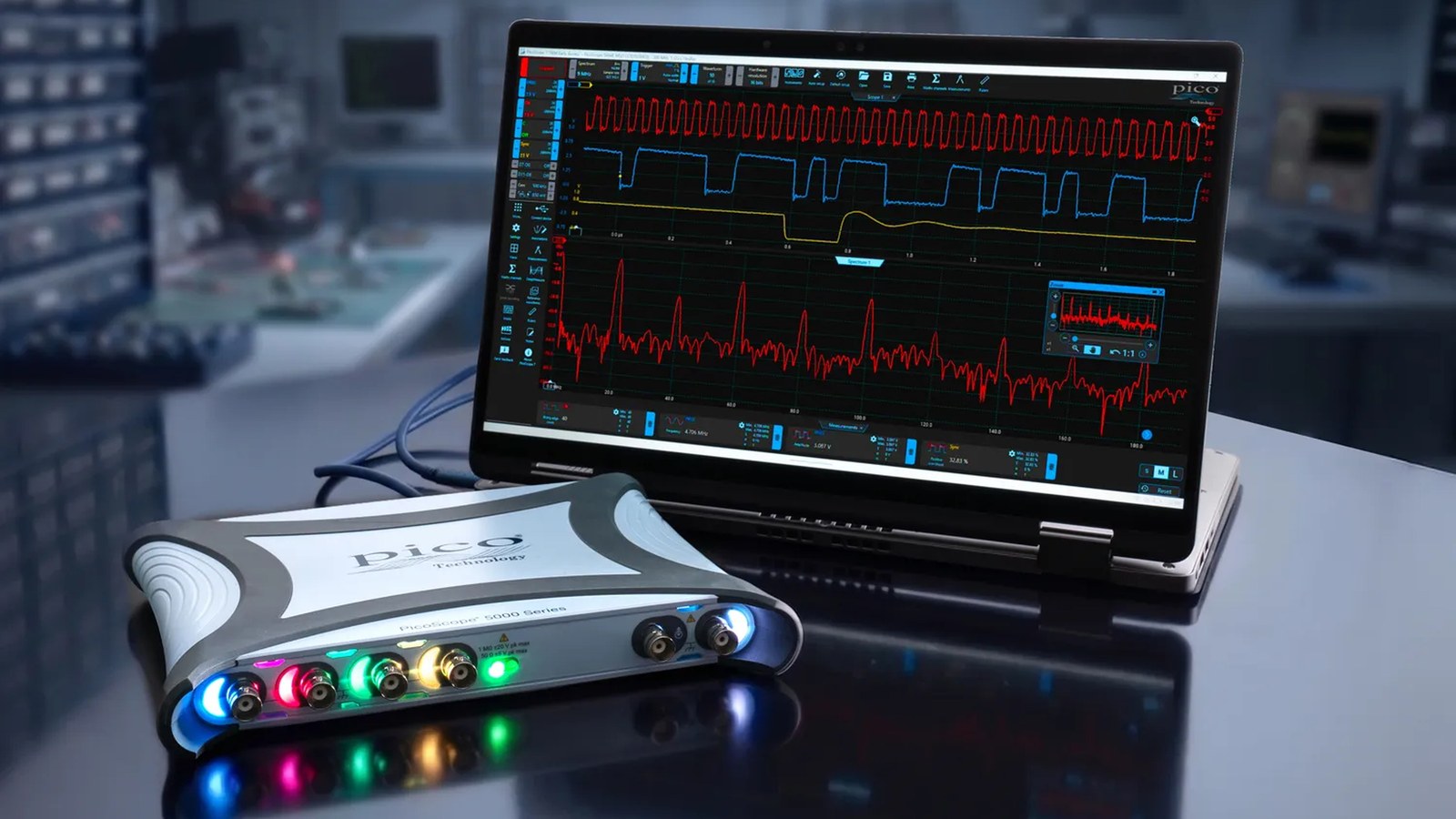 PicoScope 5000E USB oscilloscope with colored channel lights beside a laptop running PicoScope 7