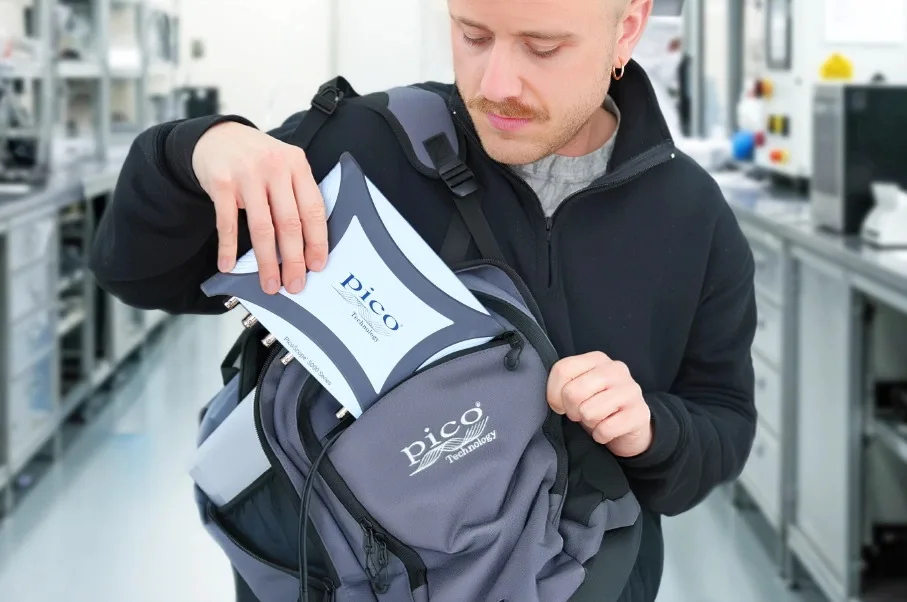A technician slipping a PicoScope into a backpack