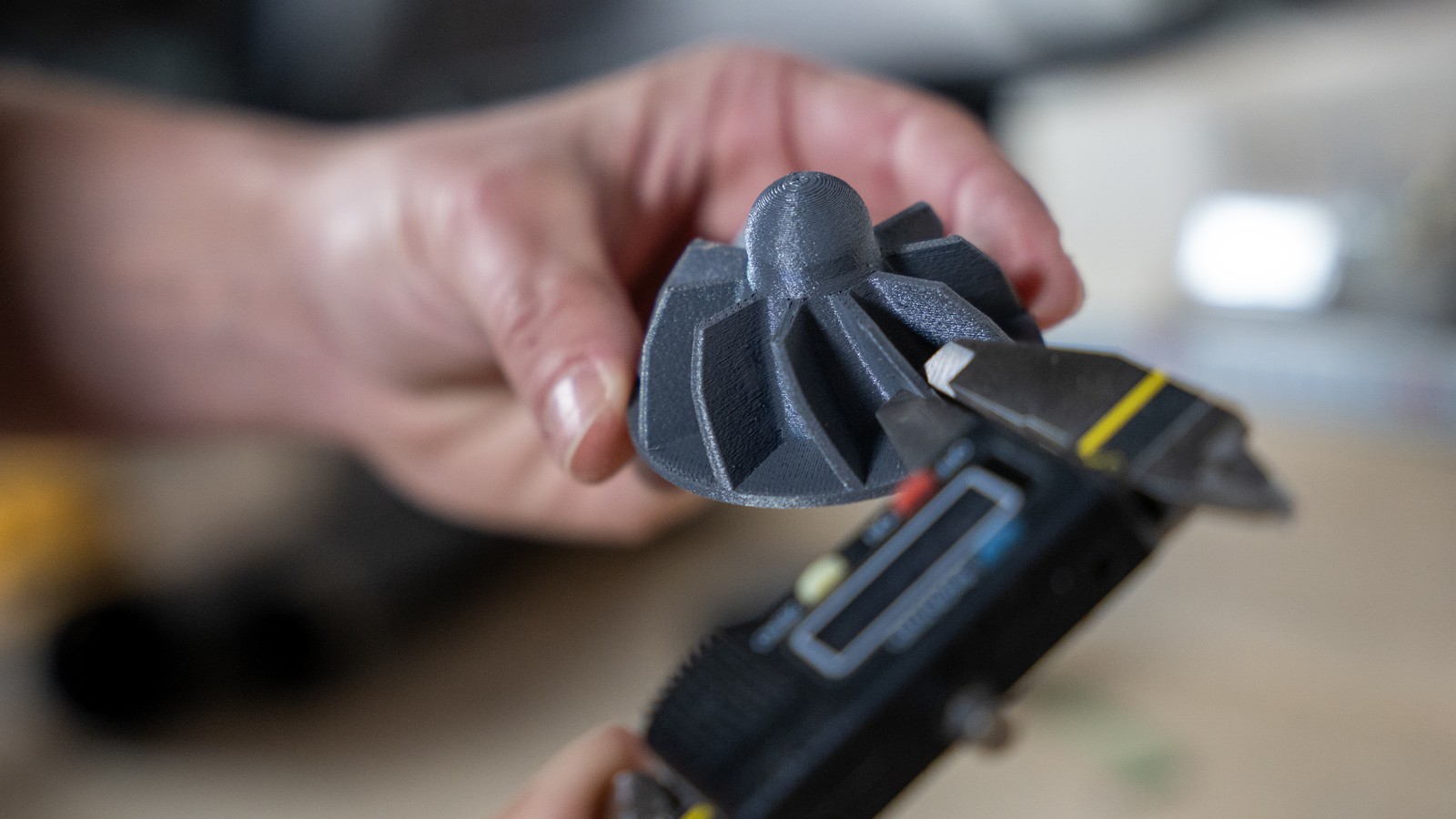 Hands holding a Prusa CORE One printhead part