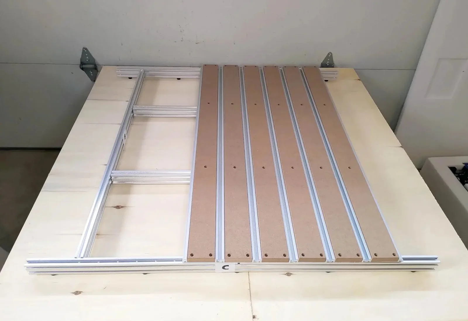 The T-slot aluminum bed with MDF spoilboard slats laid out before assembly