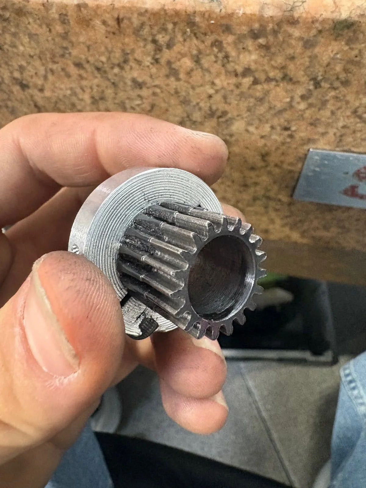 A hand holding the machined pinion gear used on the AltMill 4×8