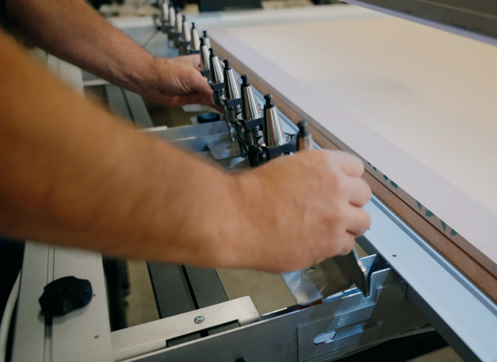 A hand sliding the tool rack onto the AltMill frame