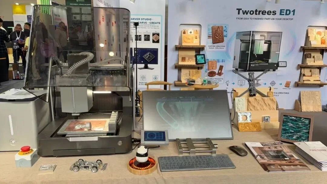 The ED1 on display at the TwoTrees IFA booth, with an enclosure, a monitor, and samples on the table