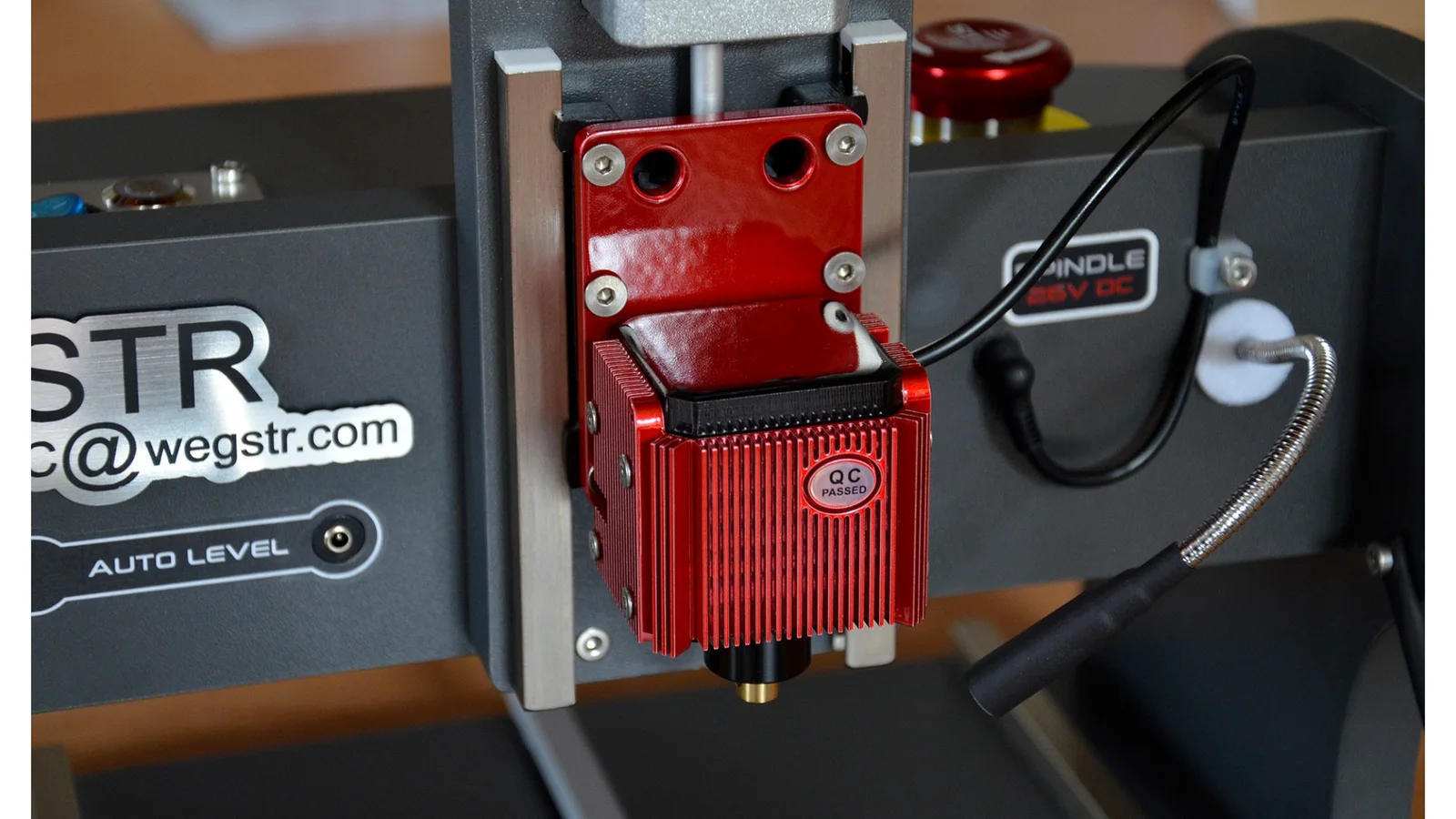 A close-up of the red spindle head with the Auto Level label and the WEGSTR name