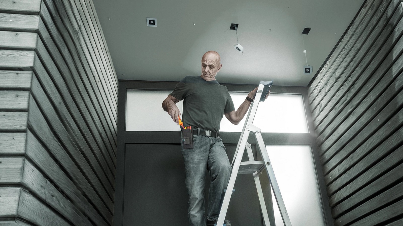 Wera press image of an electrician on a ladder using Kraftform Kompakt VDE GO