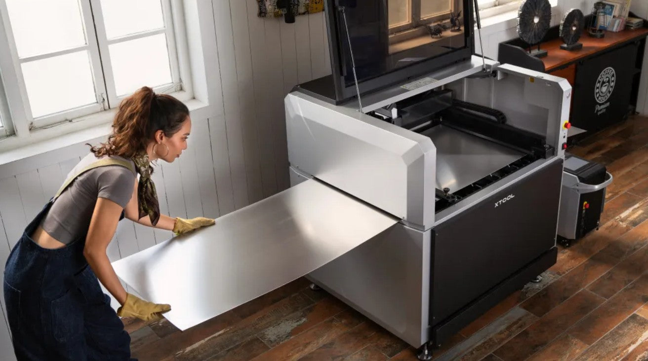 The expandable xTool MetalFab cutting table being loaded with a large metal sheet