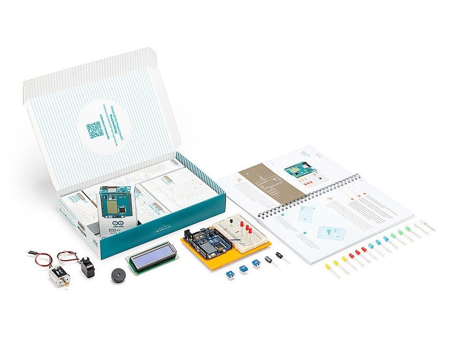 Photo of the Arduino Starter Kit R4 open on a table, showing the project book, the UNO R4 WiFi board, and the loose components inside the box