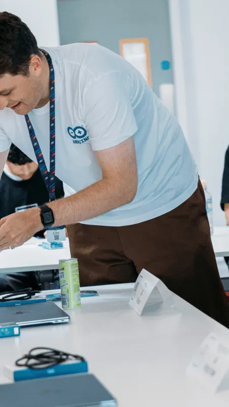 People gathered around a table with Arduino boards at an Arduino community event