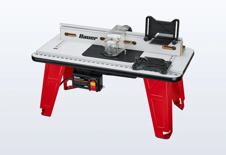 Red-legged BAUER benchtop router table with a router mounted underneath and a clear bit guard
