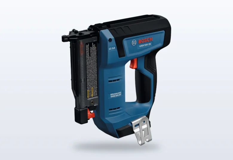 Bosch 18V cordless 23-gauge pin nailer resting against a piece of trim