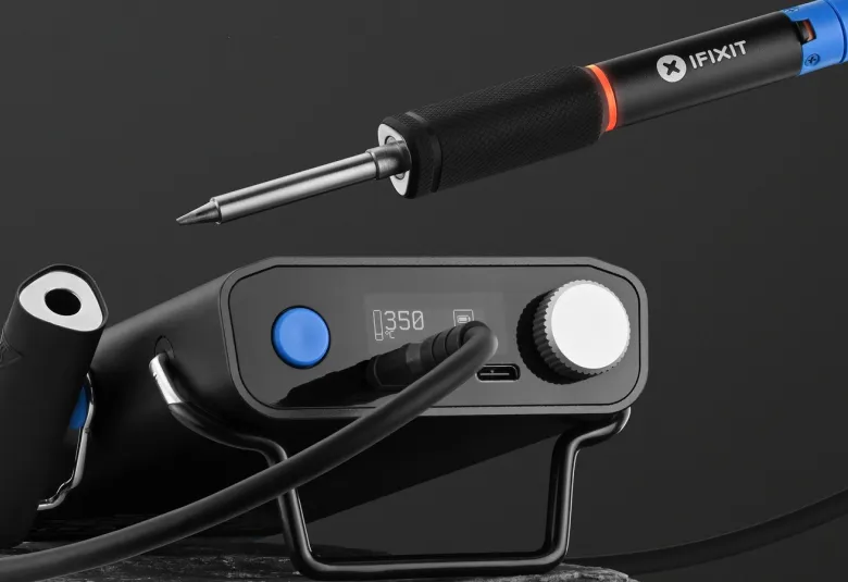 iFixit FixHub smart soldering iron resting beside its portable power station on a dark background