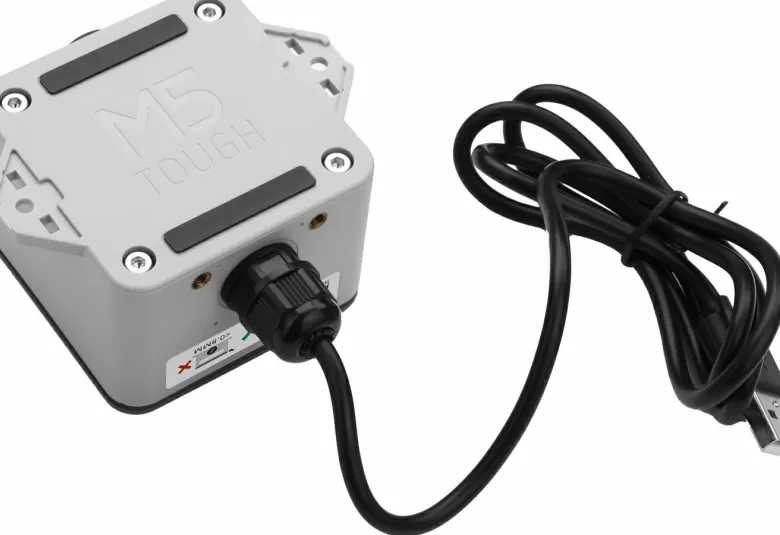 M5Stack ToughC5 controller in its gray enclosure with a cable attached