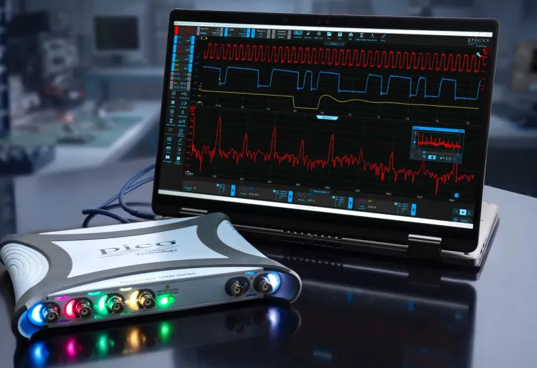 PicoScope 5000E USB oscilloscope with colored channel lights beside a laptop running PicoScope 7