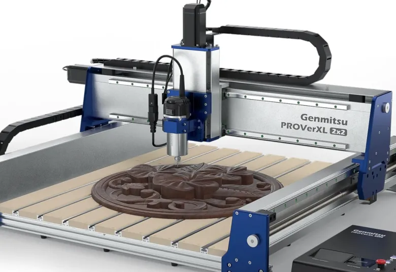 Fully assembled Genmitsu PROVerXL 2×2 CNC router with a blue and silver frame, a spindle above a slatted table holding a carved round relief, and the controller box at the front right