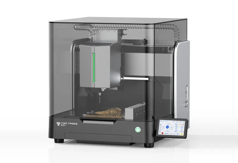 TwoTrees ED1 enclosed desktop CNC machine with a smoked glass cover, spindle and tool changer inside, a carved piece on the bed, and a touchscreen at the front right
