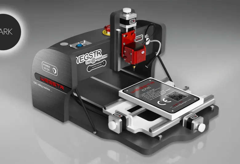 CNC Wegstr DARK desktop CNC mill in dark gray with a red spindle head and a small work plate on its sliding table