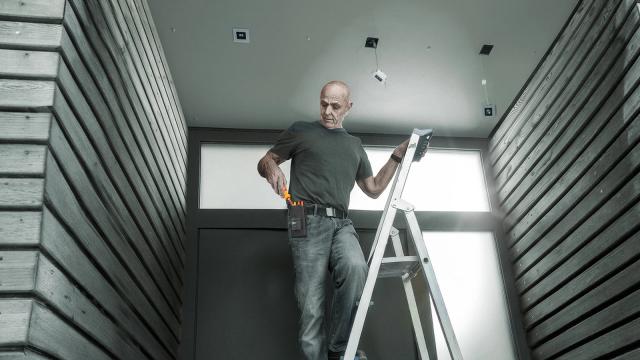 Wera press image of an electrician on a ladder using Kraftform Kompakt VDE GO