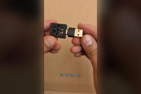 Hand holding the ESP32-C3 ad blocker board in a USB adapter
