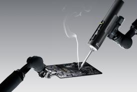 Hoto Snapbloq I-A06 cordless soldering iron working on a circuit board with a wisp of flux smoke