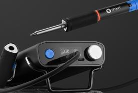 iFixit FixHub smart soldering iron resting beside its portable power station on a dark background