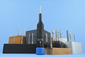 iFixit Megalodon driver with a blue cap standing among bit holders against a blue background