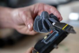 Hands holding a Prusa CORE One printhead part