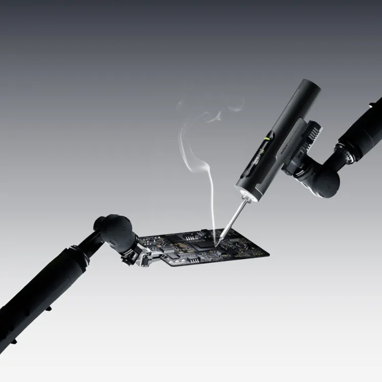Hoto Snapbloq I-A06 cordless soldering iron working on a circuit board with a wisp of flux smoke