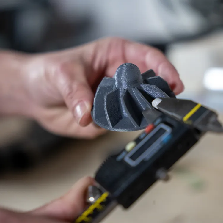 Hands holding a Prusa CORE One printhead part