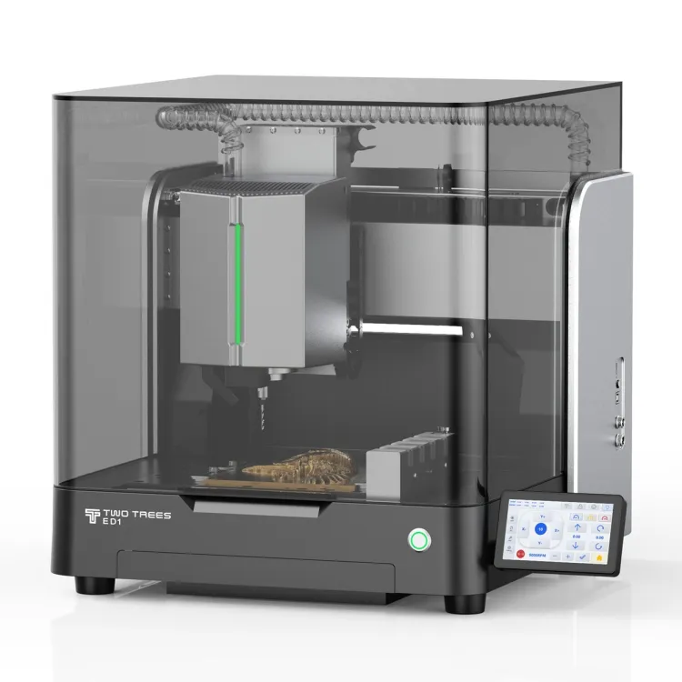 TwoTrees ED1 enclosed desktop CNC machine with a smoked glass cover, spindle and tool changer inside, a carved piece on the bed, and a touchscreen at the front right