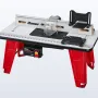 Red-legged BAUER benchtop router table with a router mounted underneath and a clear bit guard