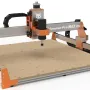 FoxAlien Masuter Pro Max 2×2 CNC router rendered on a white background, with orange end plates, a silver gantry, and a brushless spindle above a perforated MDF bed
