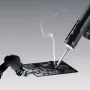 Hoto Snapbloq I-A06 cordless soldering iron working on a circuit board with a wisp of flux smoke