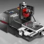 CNC Wegstr DARK desktop CNC mill in dark gray with a red spindle head and a small work plate on its sliding table